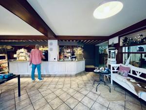 a man standing at a counter in a store at Goldener Hahn Ferienwohnungen Pool, Sauna & Frühstücksservice in Baiersbronn