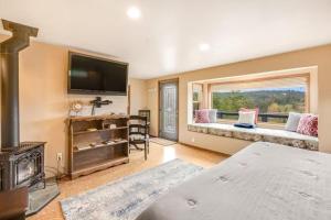 - une chambre avec un lit, une cheminée et une fenêtre dans l'établissement Deer Harbor Cottage & Suites, à Eastsound