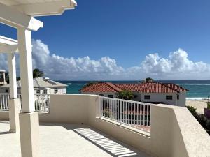 a balcony of a house with a view of the ocean at Silver Sands Beach Villas are great for family-friendly activities in Christ Church