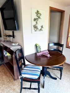 une table à manger avec deux chaises et une télévision dans l'établissement Deer Harbor Cottage & Suites, à Eastsound