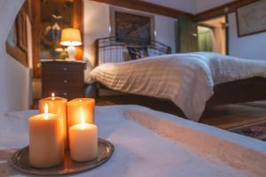 two candles sitting on a table in a bedroom at Secret garden Guest house Pozar Aridea in Aridaia