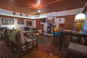 a living room with a couch and a fireplace at Secret garden Guest house Pozar Aridea in Aridaia