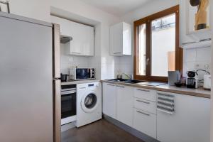 a kitchen with a washing machine and a microwave at Le Cocon Stade de France - Aux Portes de Paris - Parking Inclus in Saint-Denis +22 photos
