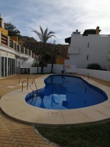 a large blue swimming pool in front of a building at Lomas del mar V in Vera