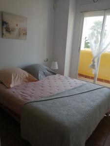 a bedroom with a large bed with a window at Lomas del mar V in Vera +4 photos