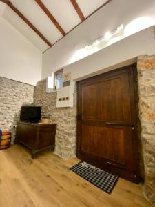 eine große Holztür in einem Zimmer mit einer Steinmauer in der Unterkunft Cevna River in Podgorica