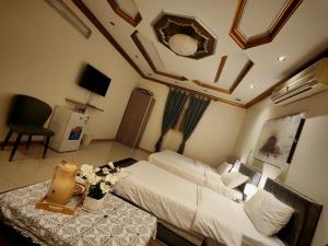 a bedroom with a bed and a table with flowers at الينبوع الأخضر in Medina