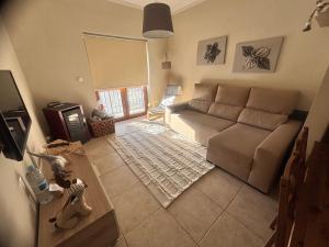 a living room with a couch and a tv at Casa da Serra - T1 - Penhas da Saúde in Penhas da Saúde