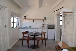 a kitchen with a table and chairs in a room at House on Pringle in Cape Town