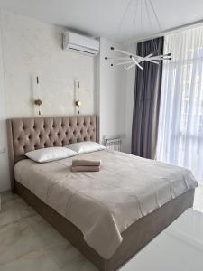 a bedroom with a large bed with a large window at Elen's Bi Residence in Batumi