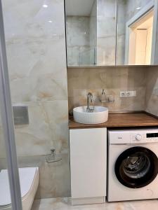 een badkamer met een wasmachine en een wastafel bij Elen's Bi Residence in Batoemi