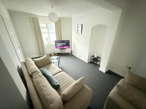 un soggiorno con un divano e una televisione di Egremont Home - Explore the Fells - Work Nearby a Woodend