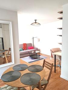 a room with a table and chairs and a living room at Le Cocon Stade de France - Aux Portes de Paris - Parking Inclus in Saint-Denis