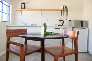 a kitchen with a table and two chairs and a counter at House on Pringle in Cape Town +8 photos