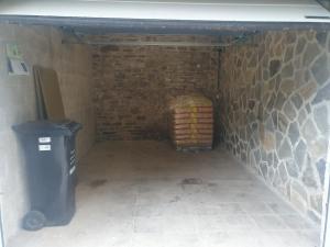 a basement with a trash can and a brick wall at Douce Mathilde in Aywaille