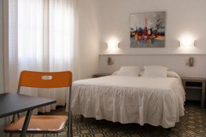 a hotel room with a bed and a table and a chair at Hostal La Florida in Llança +29 photos
