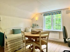 a room with a table and chairs and a bed at Charming little Swedish cottage in the Big Woods in Svängsta