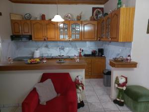 a kitchen with wooden cabinets and a red couch at Mountain View in Feneos