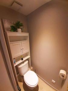 a bathroom with a white toilet and a plant at Zion Appartement SXM in Orient Bay