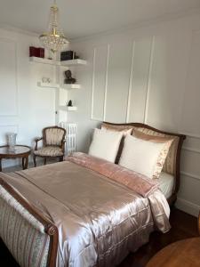 a bedroom with a large bed and a chair at Charming Stay in Saint-Ouen