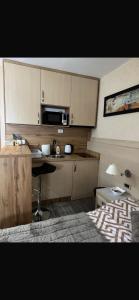 a small kitchen with a microwave and a table at Apartmani Dušica Konaci Kopaonik in Kopaonik +14 photos