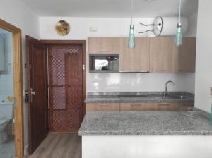 a kitchen with wooden cabinets and a counter top at Apartamento Sietu Caletillas in Santa Cruz de Tenerife