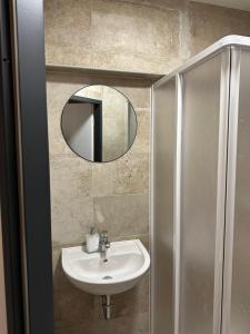 a bathroom with a sink and a mirror at SiDi Doppelzimmer in Erfurt +3 photos
