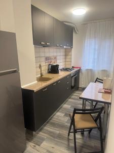 a kitchen with a sink and a table with chairs at TwinsHause in Craiova