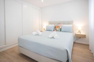 a bedroom with a large white bed with two pillows at Casa da Colina in Ferragudo