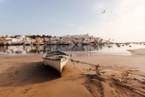 a boat sitting on the sand on the beach at Casa da Colina in Ferragudo