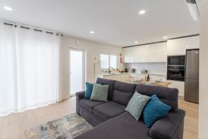 a living room with a couch and a kitchen at Casa da Colina in Ferragudo