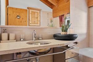 a bathroom with a sink and a vase on a counter at A&Y Wellness Chalet Didi in Davos +68 photos