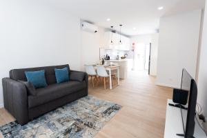 a living room with a couch and a kitchen at Casa da Colina in Ferragudo