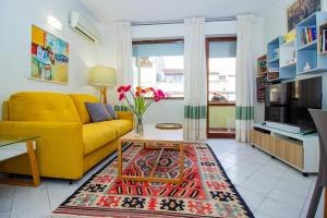 a living room with a yellow couch and a table at Casa Aurora in Sassari