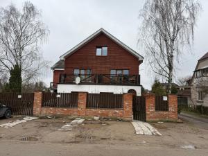 a red brick house with a fence in front of it at Villa Midesta in Šiauliai