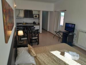 a bedroom with a bed and a kitchen with a table at Antares Apartments in Campana