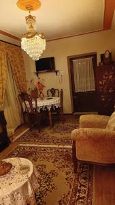 a living room with a table and a chandelier at Traditional house at Pelion seaside in Agria