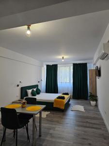 a bedroom with a bed and a table in a room at DIDI Apartament in Craiova