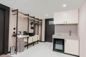 代胡克DDK Collection Hotel的带白色橱柜和水槽的厨房
