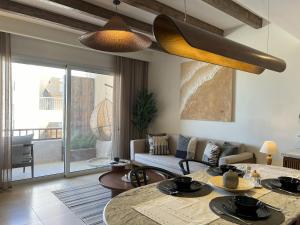 ハルガダにあるCasa De Madera - 1BR Sea & Golf View - Soma Bayのソファとテーブルと椅子のあるリビングルーム