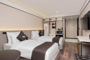 代胡克DDK Collection Hotel的有两张床和一张桌子的酒店房间