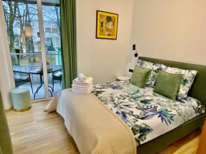a bedroom with a bed and a balcony at Alėjos Apartmentai Comfort in Druskininkai