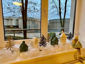 a window sill with houses and trees in the snow at Alėjos Apartmentai Comfort in Druskininkai