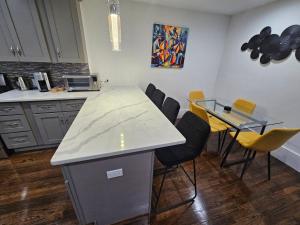 Una cocina con encimera, mesa y sillas. en Brand New 4BR House 20Min Downtown Boston, en Boston