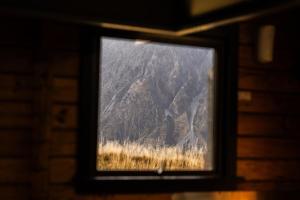 マウント・クック国立公園にあるHaka House Aoraki Mt Cookの窓越しに山の景色を望む