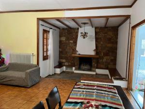 a living room with a couch and a fireplace at Σπίτι κοντά στο μύλο ξωτικών in Tríkala