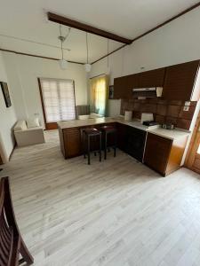 a large kitchen with wooden cabinets and chairs in it at Σπίτι κοντά στο μύλο ξωτικών in Tríkala