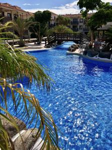ein großer Pool mit blauem Wasser in einem Resort in der Unterkunft Apartamento con piscina junto al mar in Arona