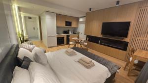 a living room with a white bed and a flat screen tv at Genex SPA in Belgrade