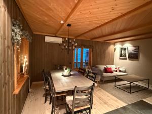 a dining room with a table and a couch at Trysil Moderna Lodge in Trysil